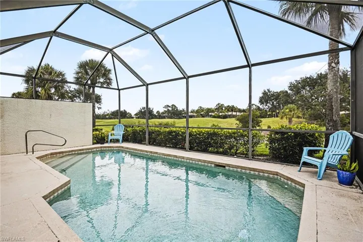 Screened pool enclosure featuring a rectangular swimming pool, integrated steps, and a handrail