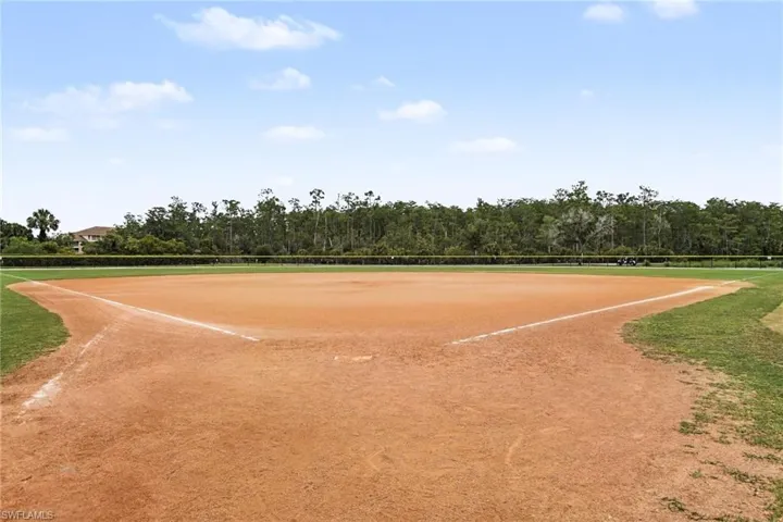 Expansive baseball field featuring a clay infield, grass outfield, and perimeter fencing