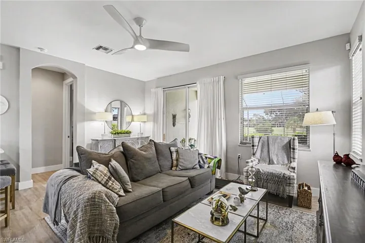 Living area featuring wood-finish flooring, a modern ceiling fan, and light gray wall paint