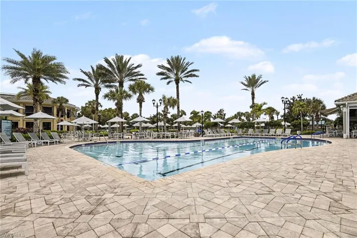 Expansive outdoor pool with integrated lap lanes, surrounded by geometric paver decking
