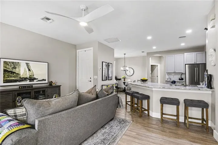 Open-concept living space featuring wood-finish flooring, recessed lighting, and a white ceiling fan
