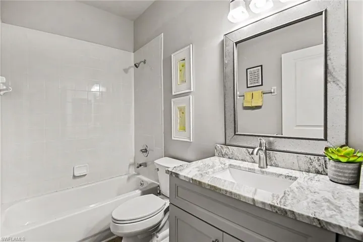 Bathroom featuring a white subway tile shower surround and a white bathtub
