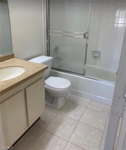 Bathroom featuring vanity, enclosed tub / shower combo, and light tile patterned floors