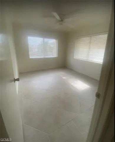 Tiled spare room with a ceiling fan