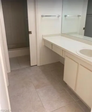 Bathroom featuring vanity, light tile patterned floors, and a shower stall
