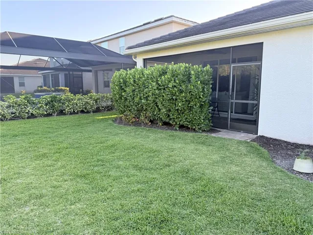 View of green lawn with a sunroom