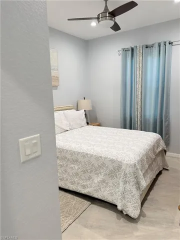 Bedroom with a textured wall and a ceiling fan