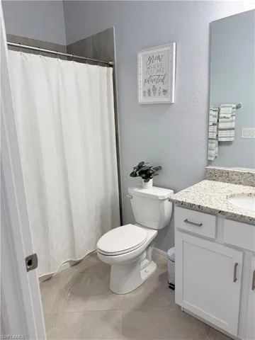 Bathroom featuring vanity, a textured wall, and a shower with curtain