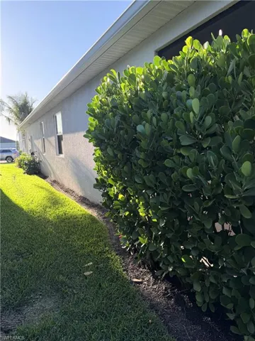 View of home's exterior featuring stucco siding and a yard