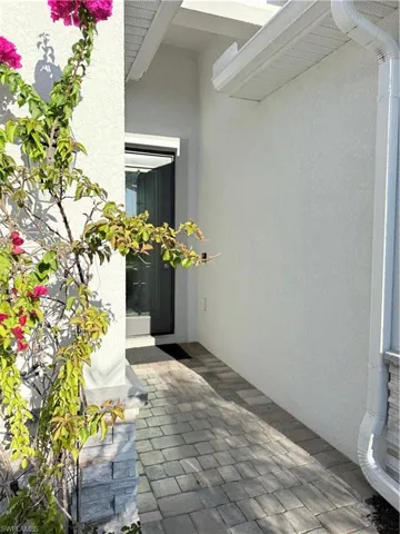 View of exterior entry featuring a patio and stucco siding