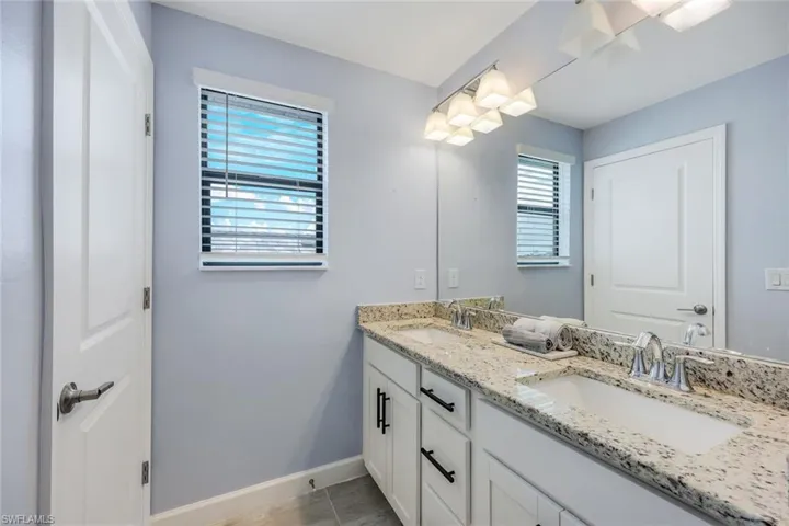 Bathroom with tile floors and dual bowl vanity