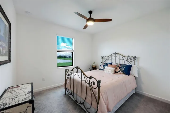 Carpeted bedroom featuring ceiling fan