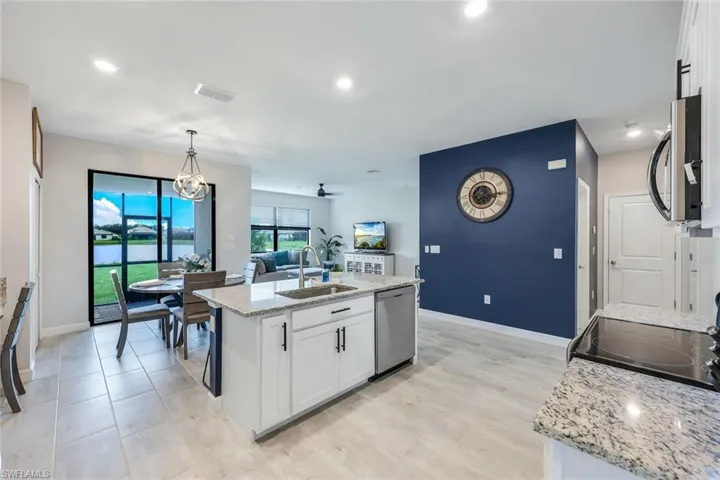 Kitchen with sink, white cabinets, a kitchen island with sink, and appliances with stainless steel finishes
