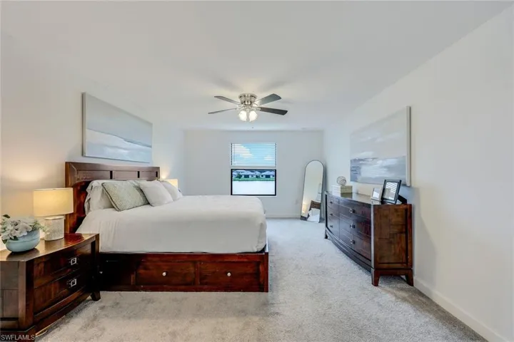 Bedroom with light carpet and ceiling fan