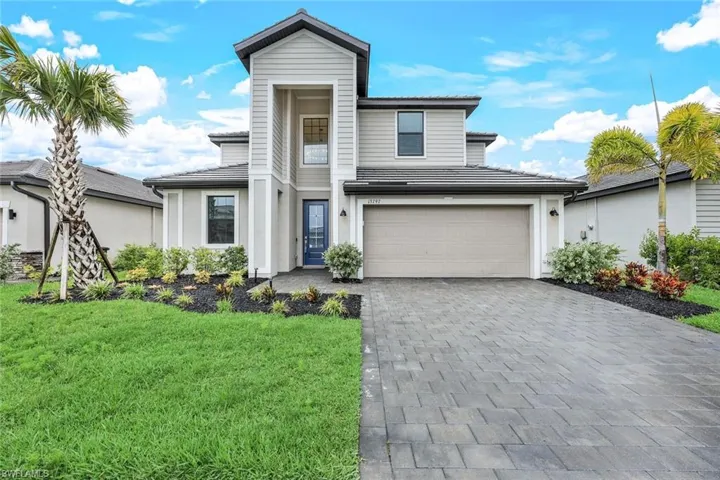 View of front of property featuring a front yard and a garage