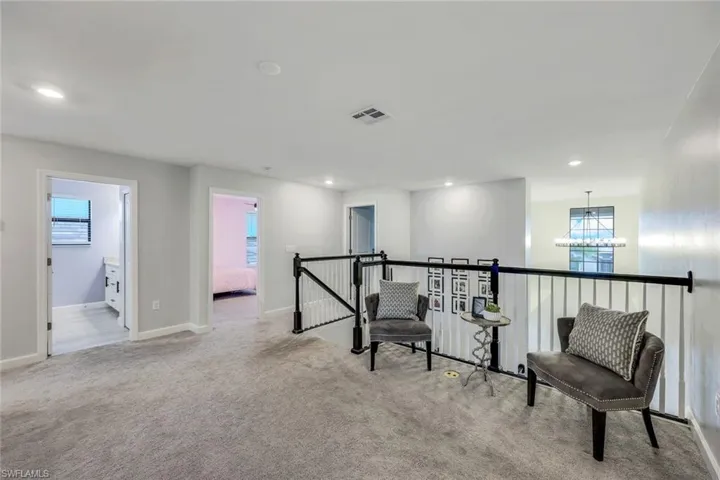 Living area with a notable chandelier and light carpet