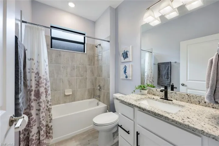 Full bathroom with oversized vanity, toilet, tile floors, and shower / bath combo