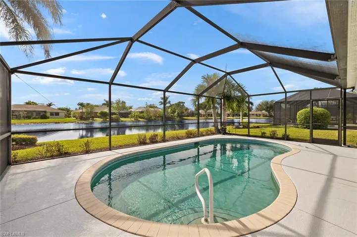 View of swimming pool with a water view, glass enclosure, and a patio area