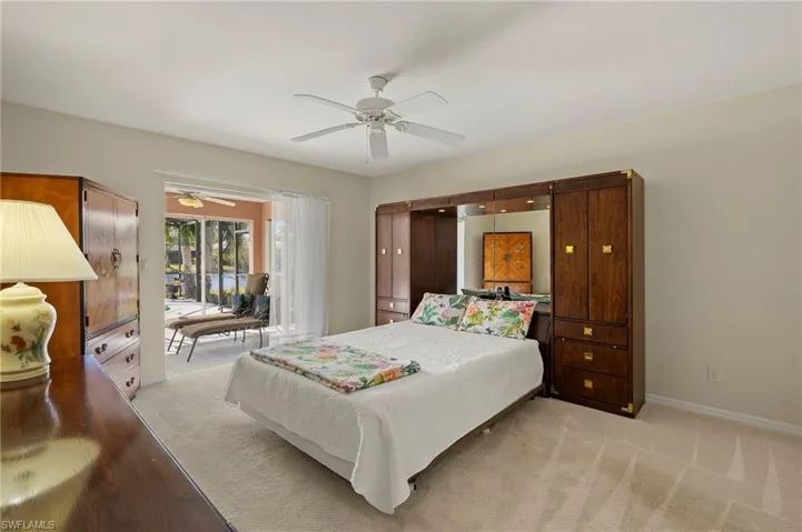 Carpeted bedroom with pocket sliders to lanai and pool.