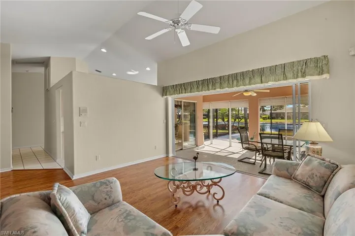 Living room spills through pocket sliders onto the screened lanai and pool.