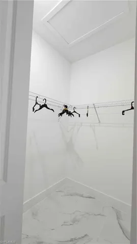 Walk in closet featuring marble finish floors