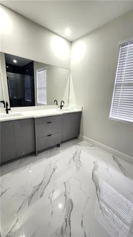 Full bath with double vanity, a shower with shower door, and recessed lighting
