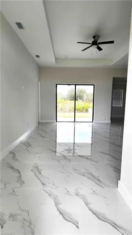 Entrance with a tray ceiling and a ceiling fan
