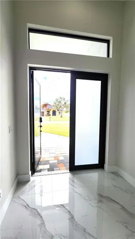 Double door Entrance foyer featuring light marble finish flooring