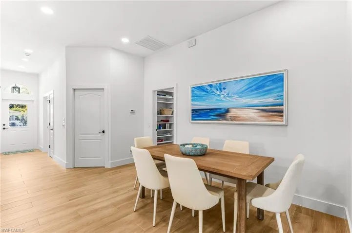 Dining room with light wood-type flooring and recessed lighting