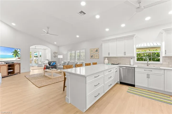 Kitchen with ceiling fan, a peninsula, recessed lighting, and white cabinets