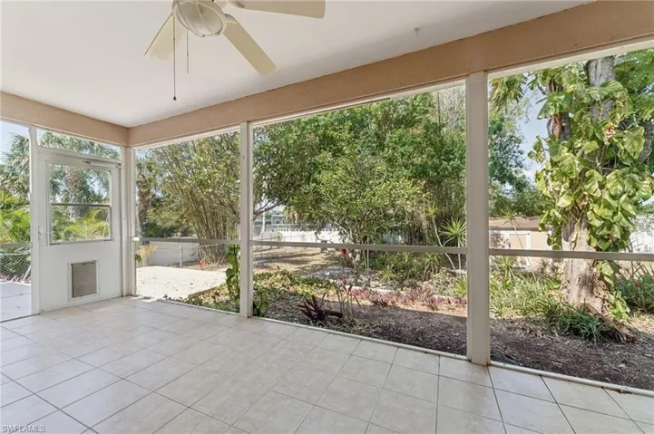 Unfurnished sunroom featuring a ceiling fan