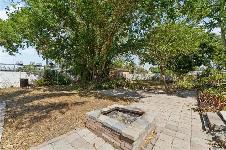 View of yard featuring a fire pit, a patio area, and a fenced backyard