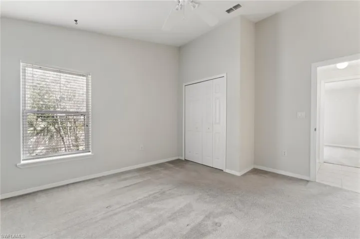 Unfurnished bedroom featuring a closet, ceiling fan, carpet floors, baseboards, and visible vents