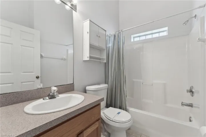 Full bathroom with shower / tub combo, vanity, and toilet