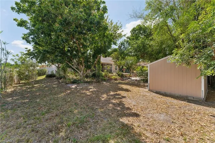 View of yard featuring an outbuilding and fence