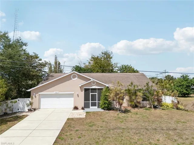Single story home featuring driveway, fence, a garage, a front yard, and stucco siding