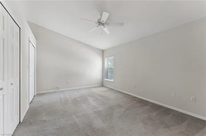 Unfurnished bedroom with baseboards, light colored carpet, and ceiling fan