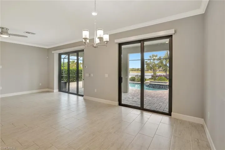 Spare room featuring crown molding, baseboards, a notable chandelier, and visible vents