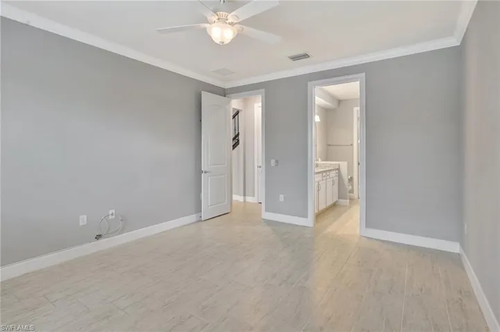 Unfurnished bedroom with baseboards, ornamental molding, and visible vents
