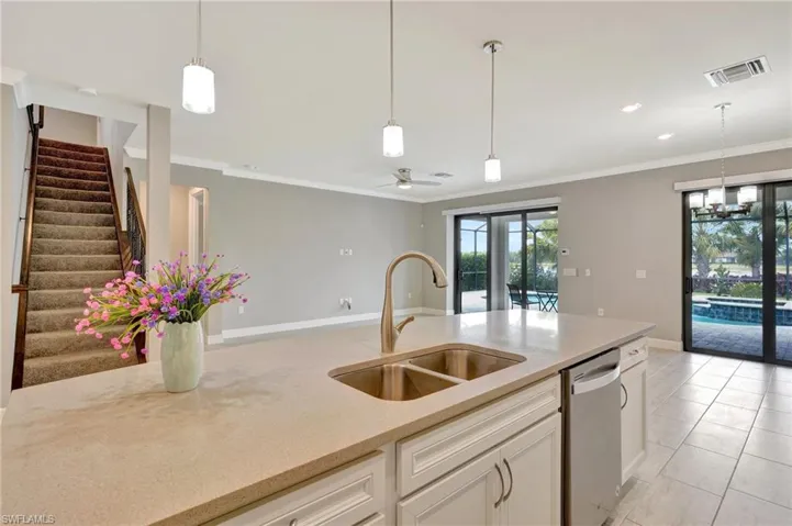 Kitchen with hanging light fixtures, visible vents, a sink, and dishwasher