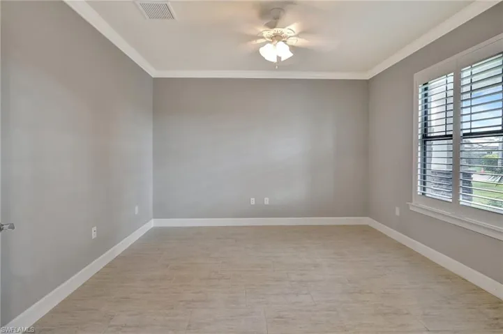 Unfurnished room featuring visible vents, ornamental molding, and a healthy amount of sunlight