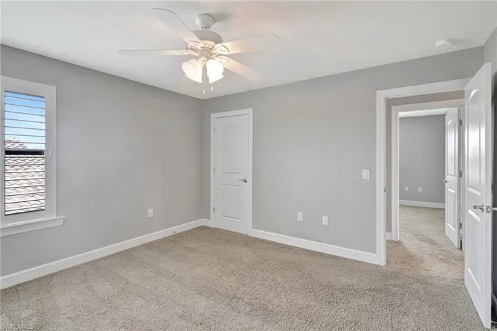 Unfurnished bedroom featuring baseboards, ceiling fan, and carpet flooring