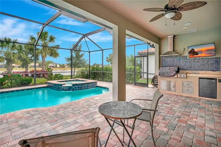 View of swimming pool with a sink, area for grilling, a patio area, a ceiling fan, and a grill