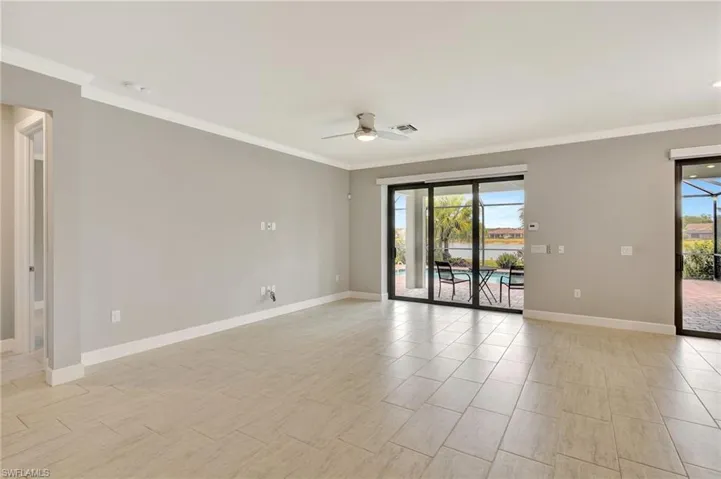 Empty room with baseboards, ornamental molding, a ceiling fan, and visible vents