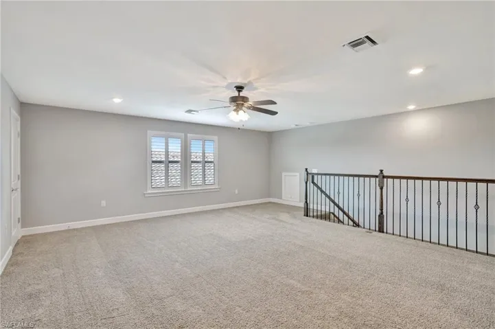 Unfurnished room featuring light carpet, a ceiling fan, baseboards, recessed lighting, and visible vents