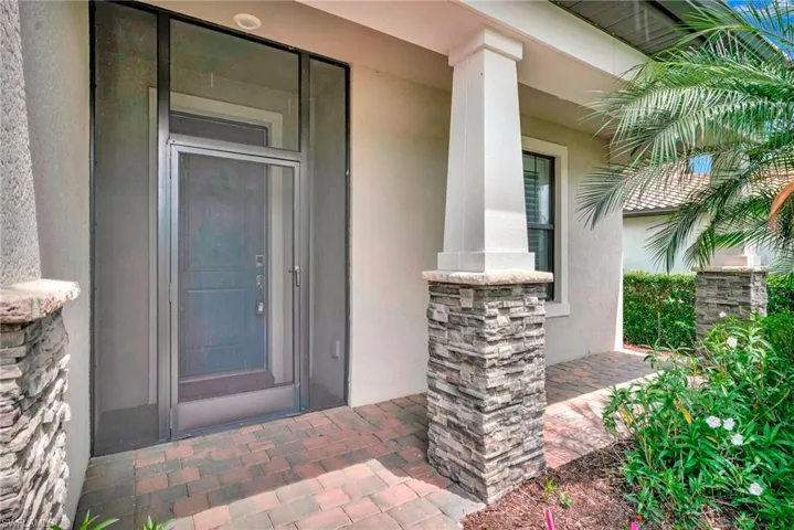 View of exterior entry with covered porch and stucco siding