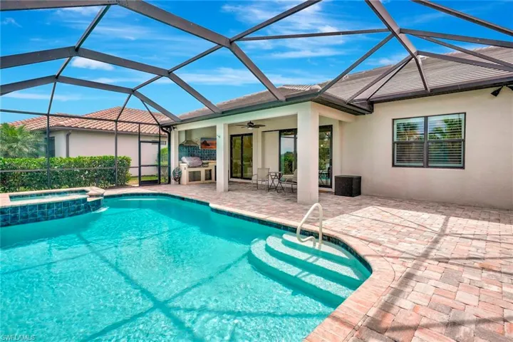 View of pool with a ceiling fan, a lanai, a pool with connected hot tub, and a patio area
