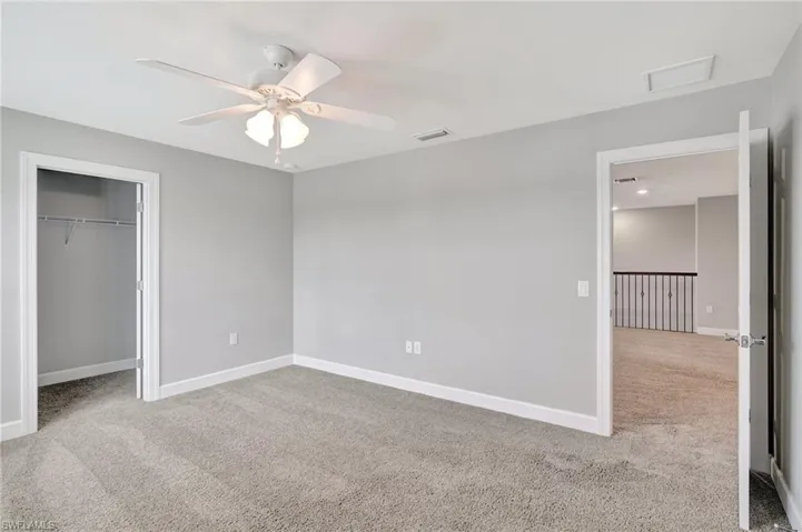 Unfurnished bedroom featuring carpet flooring, baseboards, visible vents, and a closet