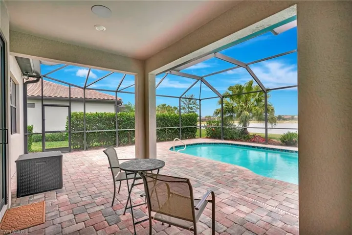 View of swimming pool with glass enclosure, a fenced in pool, and a patio area