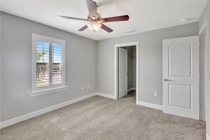 Unfurnished bedroom featuring carpet floors, baseboards, visible vents, and a walk in closet